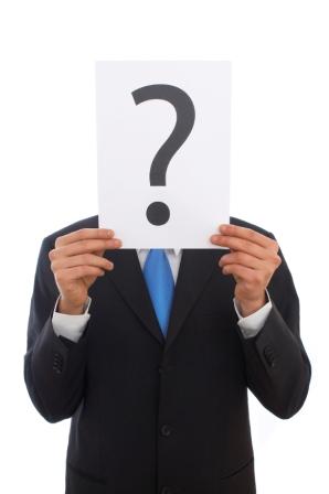 man holding question mark in front of face